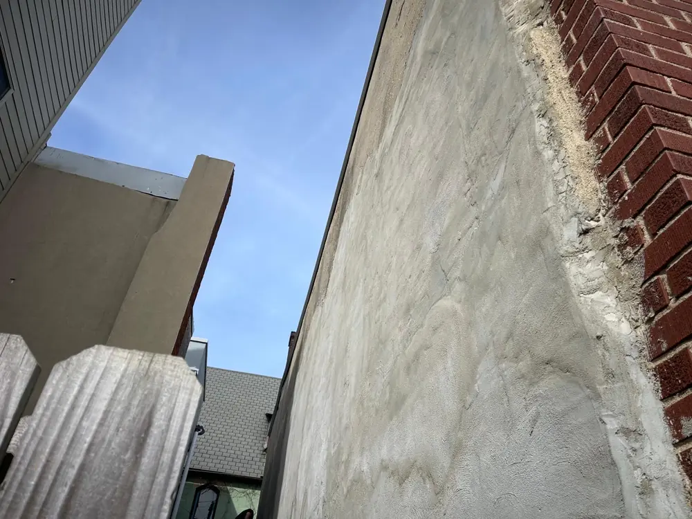 Finished exterior stucco wall next to brick