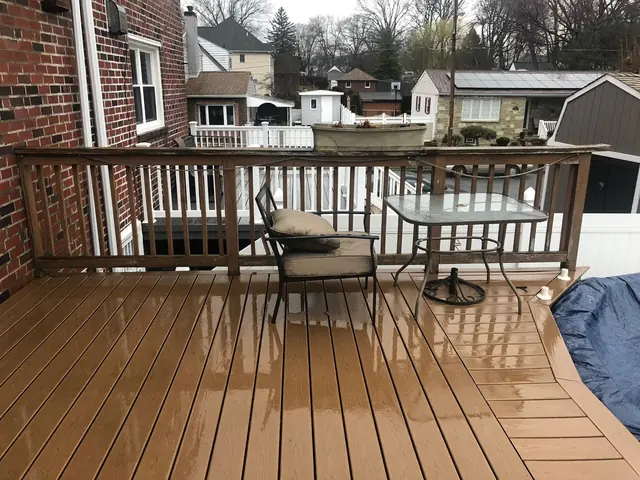 Composite deck with railing behind a brick row home